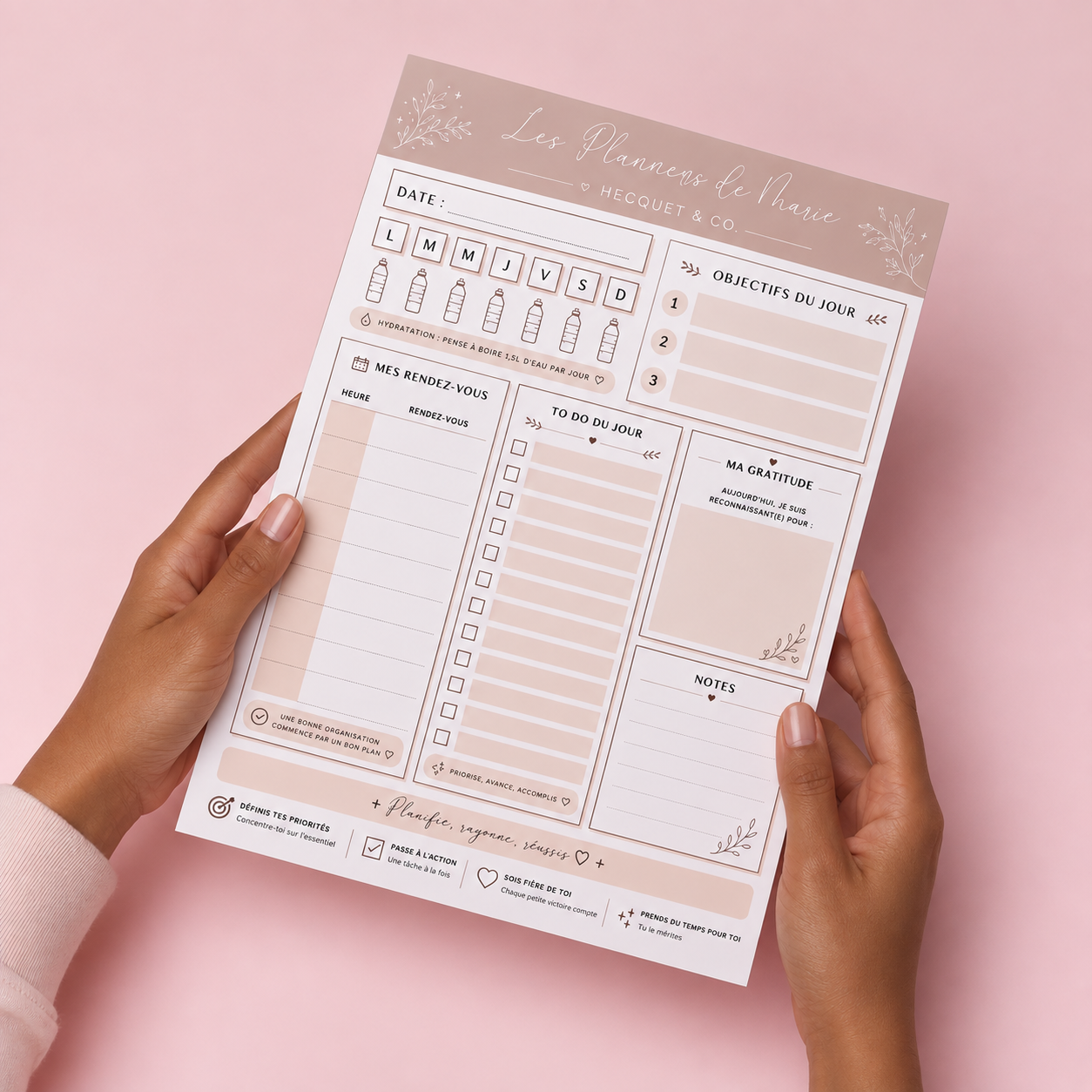 Bloc-note To Do du Jour tenu en main sur fond rose, Les Planners de Marie